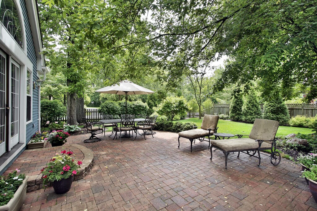 Brick patio with table umbrella and chairs. Your Patio in Summer